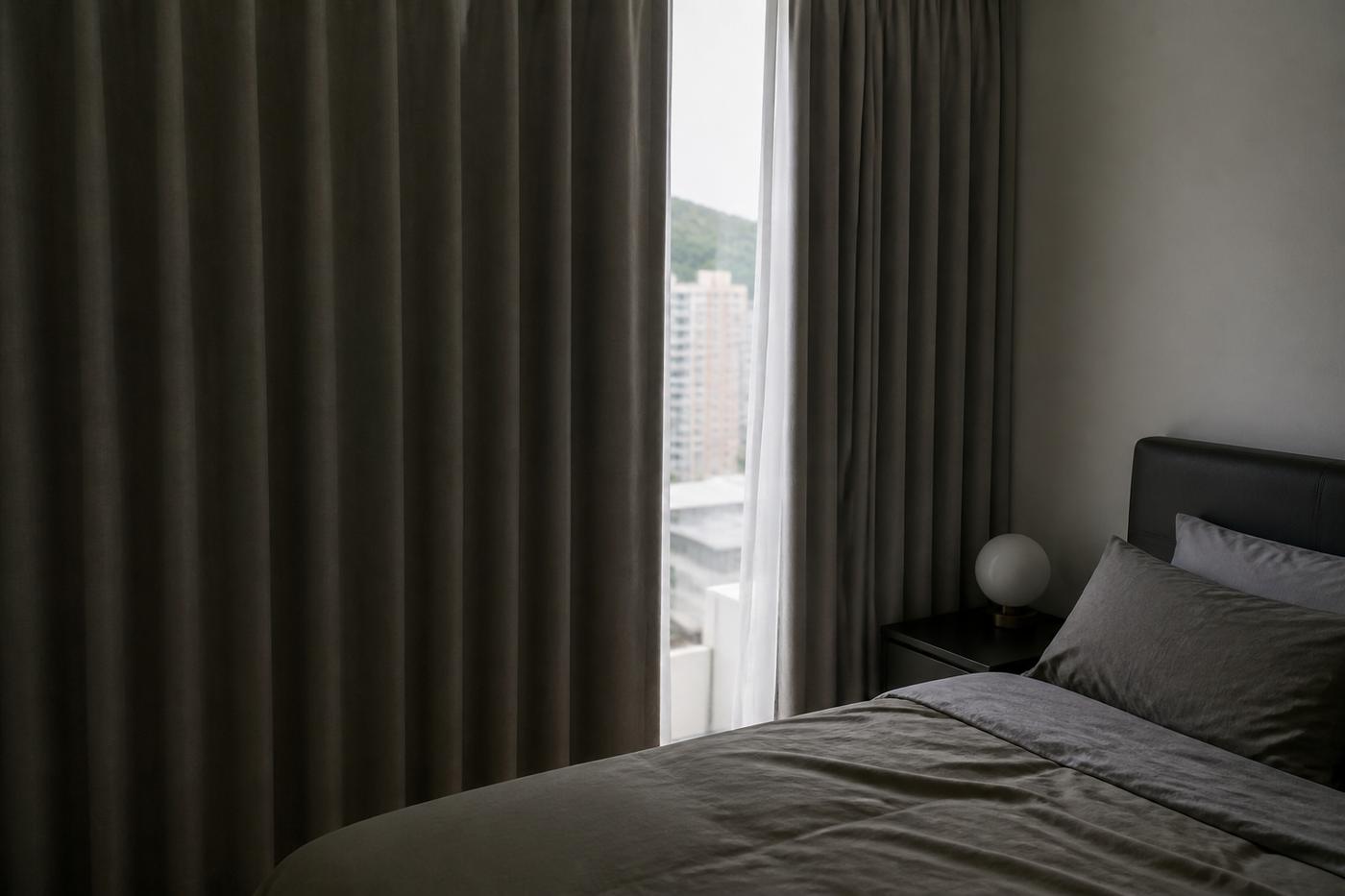 Bedroom with soft grey curtains partly drawn