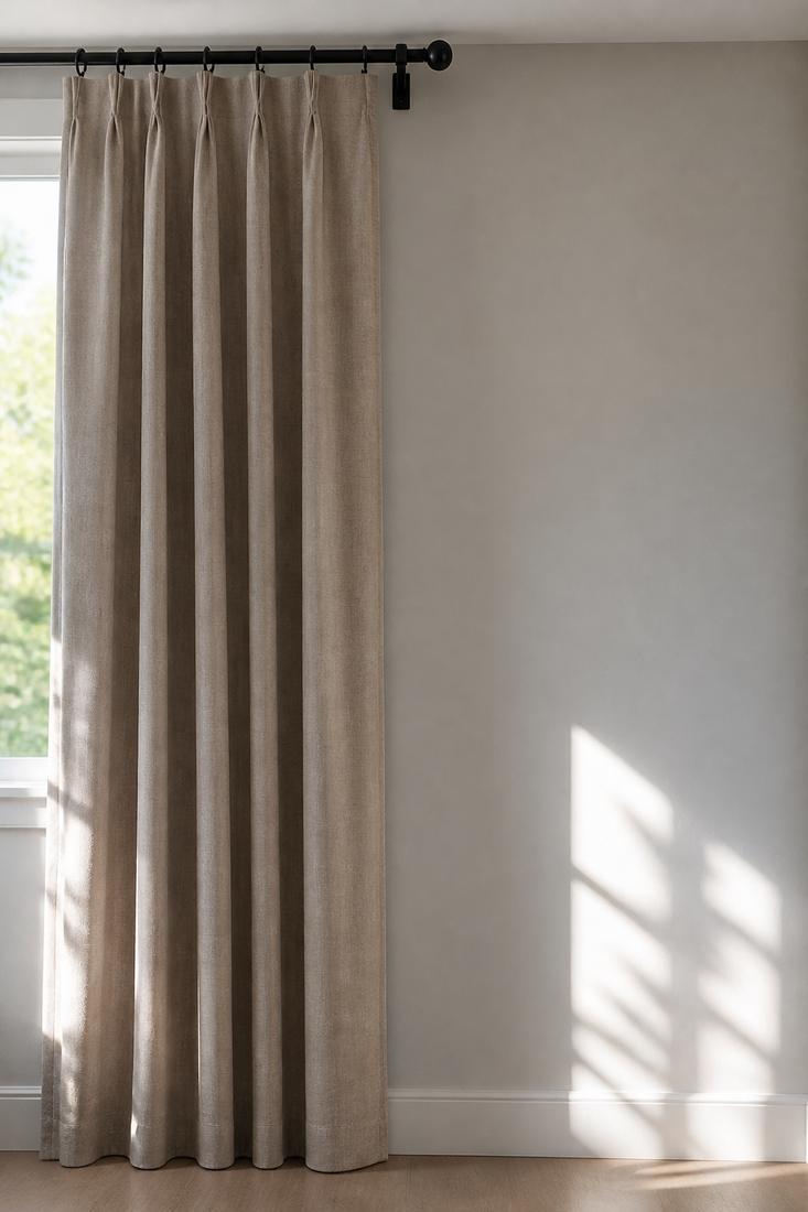 Taupe curtain panels hanging on a metal rod